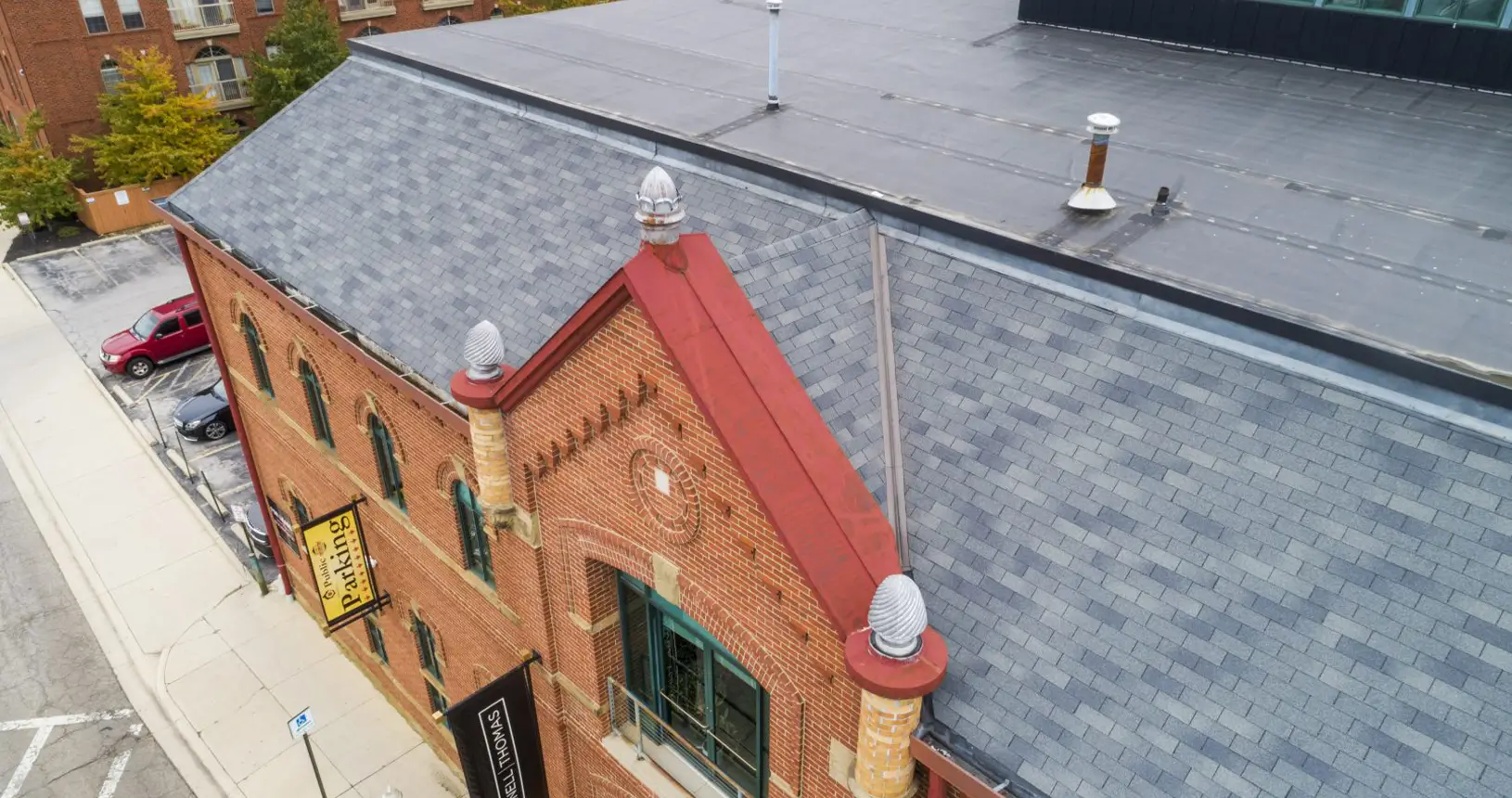 Diagonal view of the Worly Building in Columbus with newly installed shingle & rubber commercial roofing.